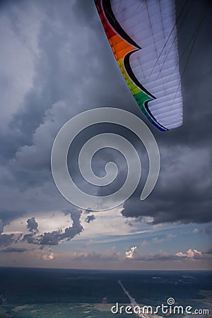 The paraglider under the thunderclouds, the multi-colored wing Stock Photo