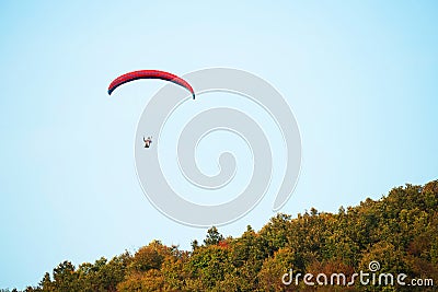 A man flies in his paraglider near Siria Medieval Fortress in Arad County, Romania. Editorial Stock Photo