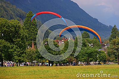 SWITZERLAND, INTERLAKEN, AUGUST 02, 2022 - Tourists paragliding in Interlaken, Bernese Oberland, Switzerland Editorial Stock Photo