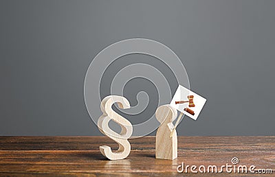Paragraph symbol and man with a drawing of a judge hammer gavel on a sign. Call to trial against a criminal or a corrupt official Stock Photo