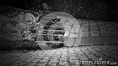 Parallelepiped covered street and rocky steps in black and white Stock Photo