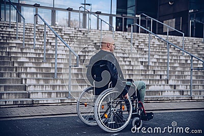 Paralyed man sitting on wheel chairin front of the stairs Stock Photo