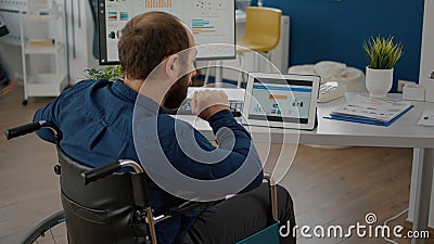 Paralyzed manager man using computer and tablet in same time Stock Photo