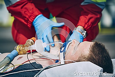 Paramedic of emergency medical service helping man after resuscitation Stock Photo