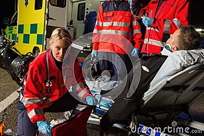 Paramedics assisting injured motorcycle man driver Stock Photo