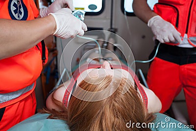 Paramedics helping woman inside ambulance Stock Photo