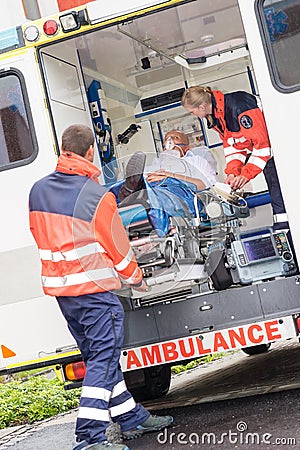 Paramedics putting patient in ambulance car aid Stock Photo