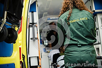 Paramedics rolling a young patient on an ambulance stretcher Stock Photo