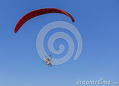 Paramotor flying on blue sky background Stock Photo