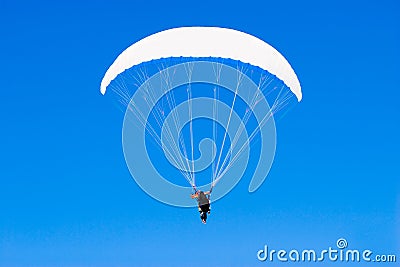 A paraplane flying high up in the deep blue sky Stock Photo