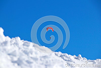 Paraplane flying over snowy Caucasus mountains sunny blue sky Stock Photo