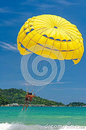 Parasailing is a popular water sport in Patong Beach, Thailand. People flying on colorful parachute towed by speed boat with a cle Editorial Stock Photo