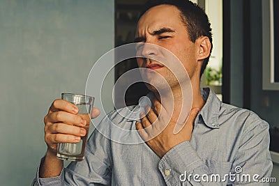 A parched throat and a glass of water in hand Stock Photo