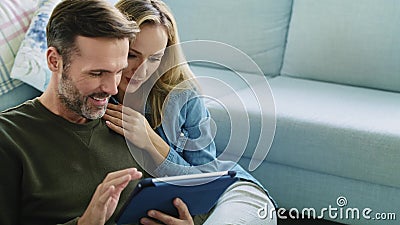 Pareja con comprimido en el salón Pareja con comprimido en el salón