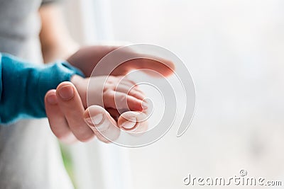 Parent Holding in the Hands hand of Newborn Baby. Parent Care of Newborn Baby. concept of parenthood and love Stock Photo