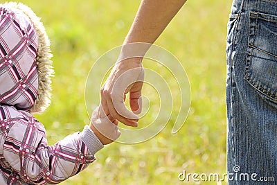 Parent holds the hand of a child Stock Photo