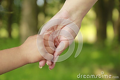 Parent holds the hand of a small child Stock Photo