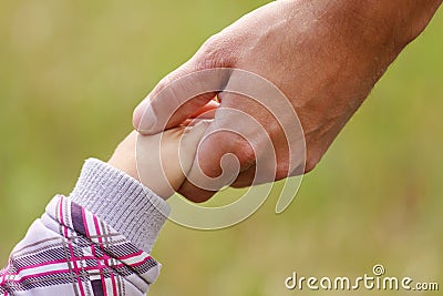 Parent holds the hand of a small child Stock Photo