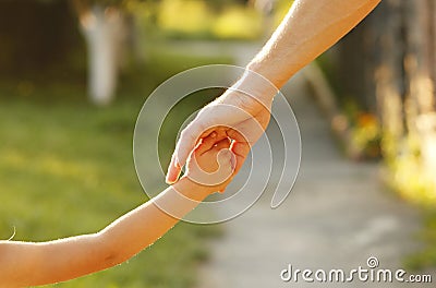 Parent holds the hand of a small child Stock Photo