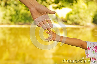 Parent holds the hand of a small child Stock Photo