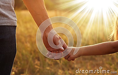 The parent holds the hand of a small child Stock Photo
