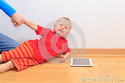 Parent pulling child from touch pad Stock Photo