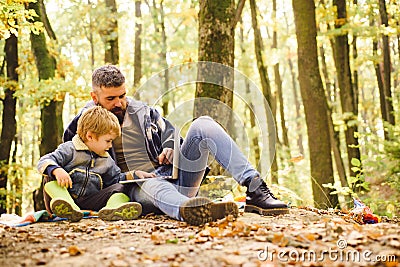 Parent teach baby. Dad and son using laptop the park. Father and son playing in the autumn forest. Stock Photo