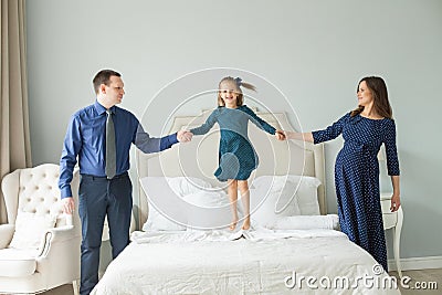 Parental care concept. Happy family jumping on the bed Stock Photo