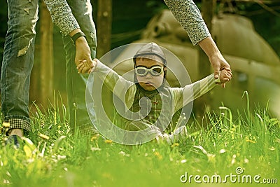 Parental care. Son baby in pilot helmet holding hands with mother Stock Photo