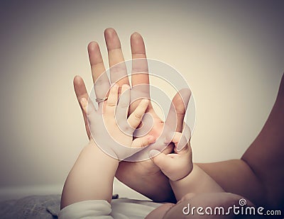 Parenthood. Mother and her little baby touching each other hands Stock Photo