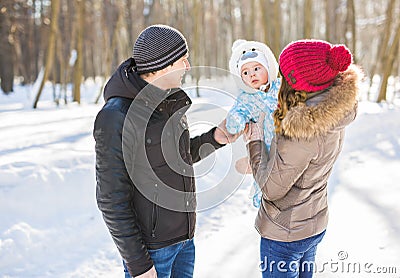 Parenthood, season and people concept - happy family with child in winter clothes outdoors Stock Photo