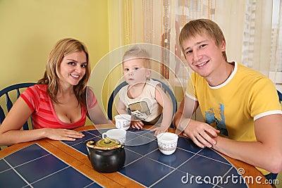 Parents with child drink tea in room 2 Stock Photo