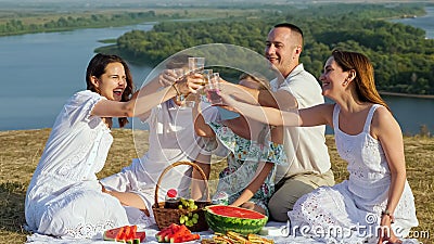 Parents with children clink glasses of soft drinks at picnic Stock Photo