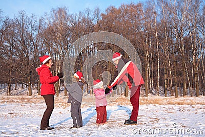 Parents and children in red hats play in winter Stock Photo