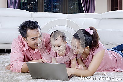 Parents with cute baby using a laptop Stock Photo