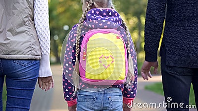 Parents and daughter going to school, conscious parenthood, care, back view Stock Photo