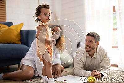 Parents encourage young daughter to express her emotions, cultivate creativity Stock Photo