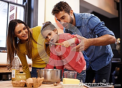 Parents, girl and kitchen for baking with love, ingredients for cake or dessert with support and handmade with care. Mom Stock Photo