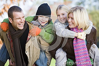 Parents giving children piggyback ride Stock Photo