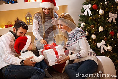 Parents giving Christmas gift to son Stock Photo