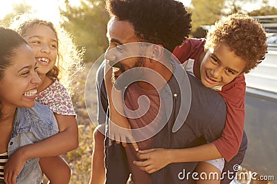 Parents giving their kids piggybacks, waist up, close up Stock Photo