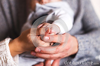Parents hold baby`s hands close. Stock Photo