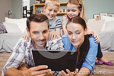 Parents holding digital tablet while kids sitting on their back Stock Photo