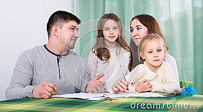 Parents with little children buying insurance and smiling Stock Photo