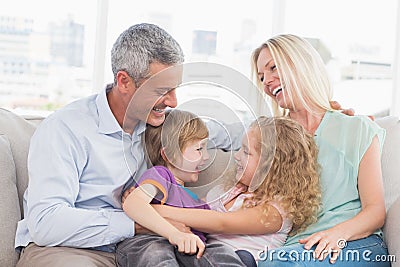 Parents looking at children hugging at home Stock Photo