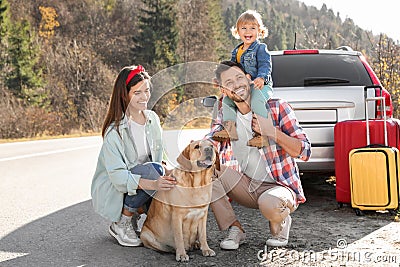 Parents, their daughter and dog near road. Family traveling with pet Stock Photo