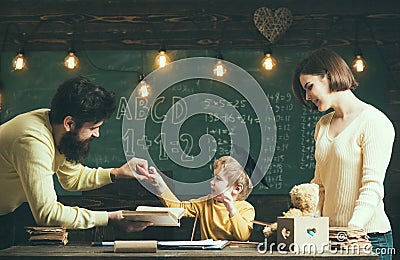 Parents wants to grow up genius son. Wunderkind and genius concept. Father, teacher reading book, teaching kid, son Stock Photo