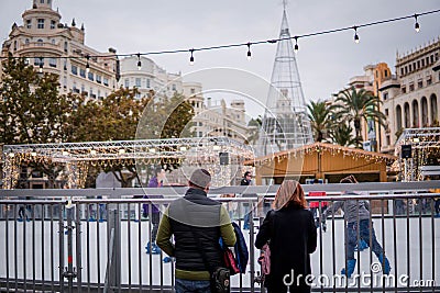Parents Watching Children Ice Skating on Christmas Rink in the Plaza del Ayuntamiento of Valencia Editorial Stock Photo