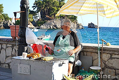 Parga, Greece, July 17 2018 An elderly lady sells cobs of roasted corn Editorial Stock Photo