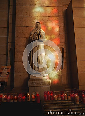 Paris, 20 December 2018. Inside the Cathedral of Notre Dame. statue of the mother of God in the sun and the colored glare Editorial Stock Photo